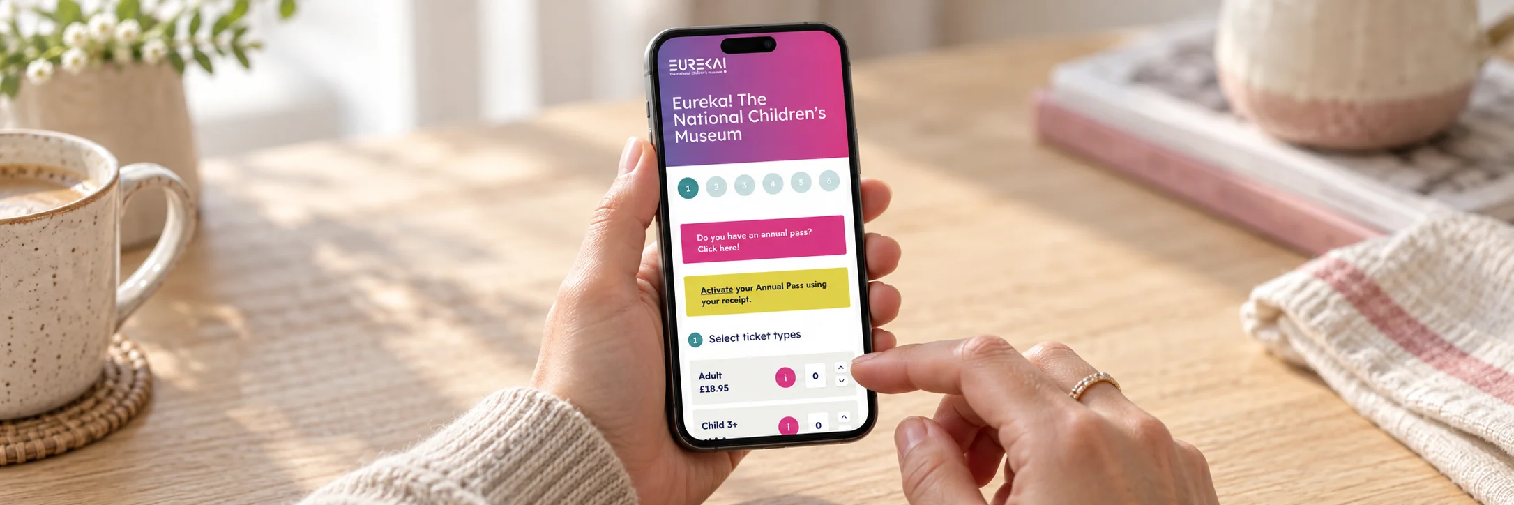 A visitor choosing Eureka! museum tickets on a phone at home.