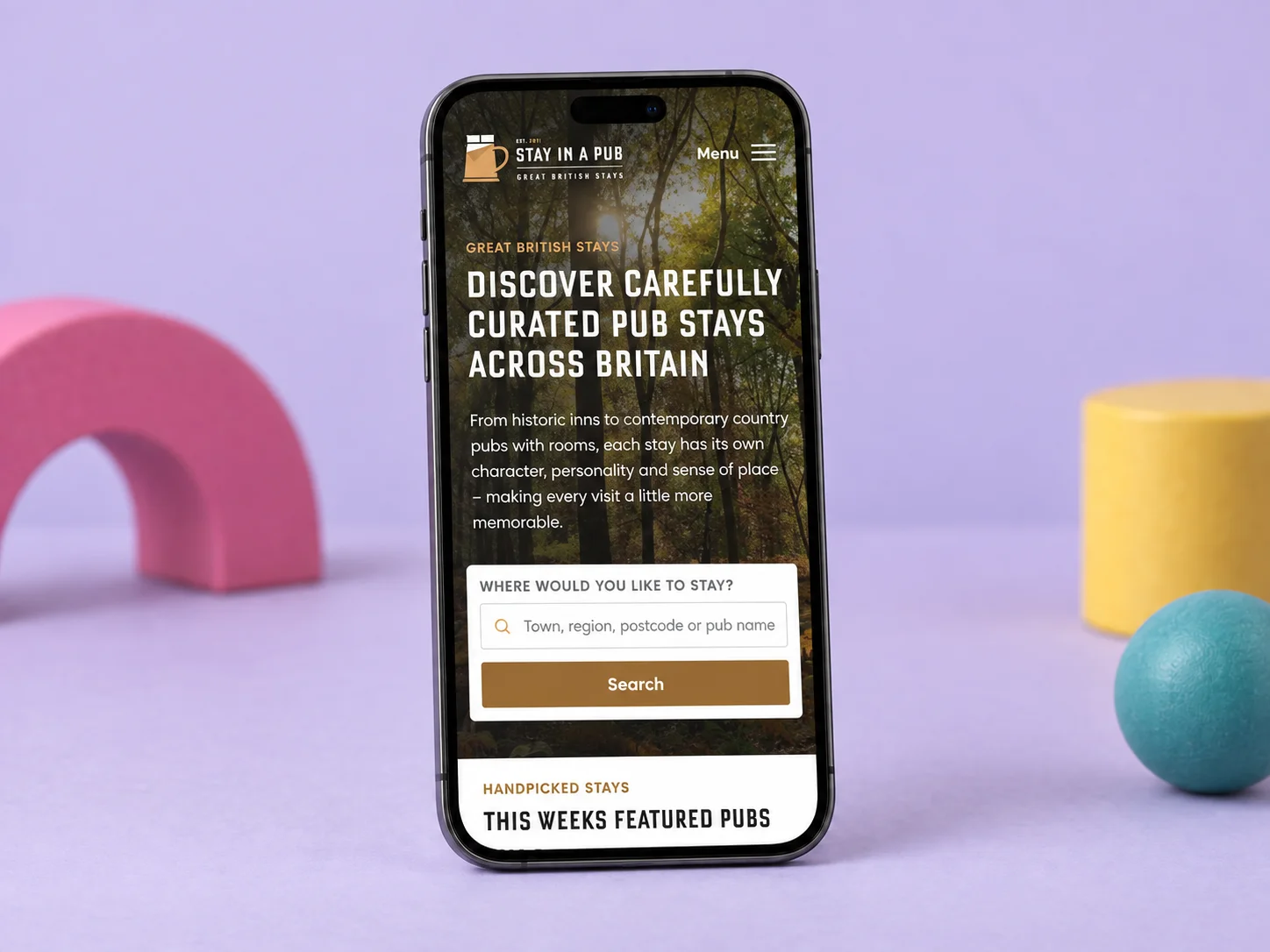 The new Stay in a Pub homepage on a mobile phone, with its woodland introduction and pub search.